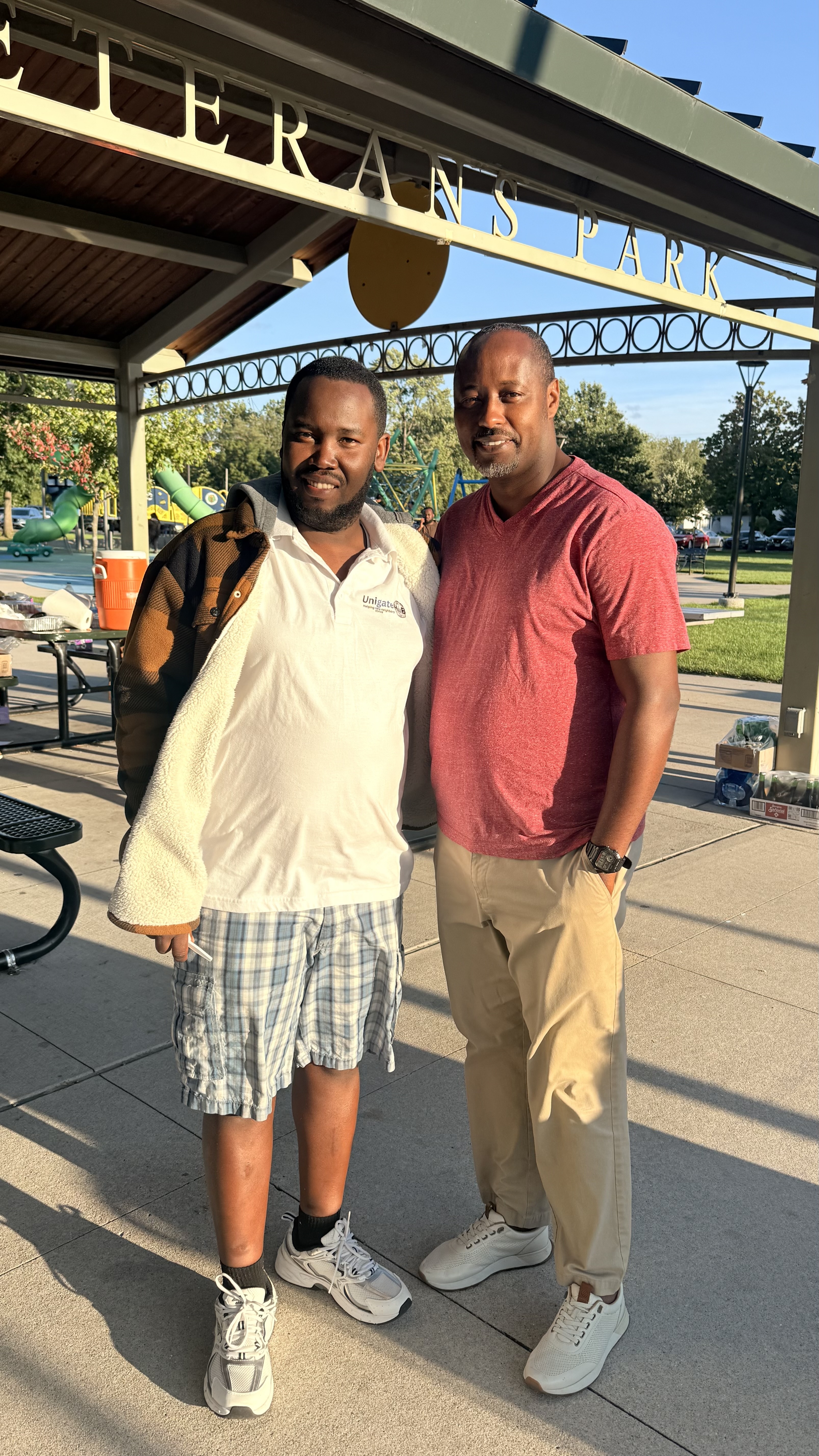 Two community members pose at the outdoor pavilion during Iwacu Rwanda Family Day.