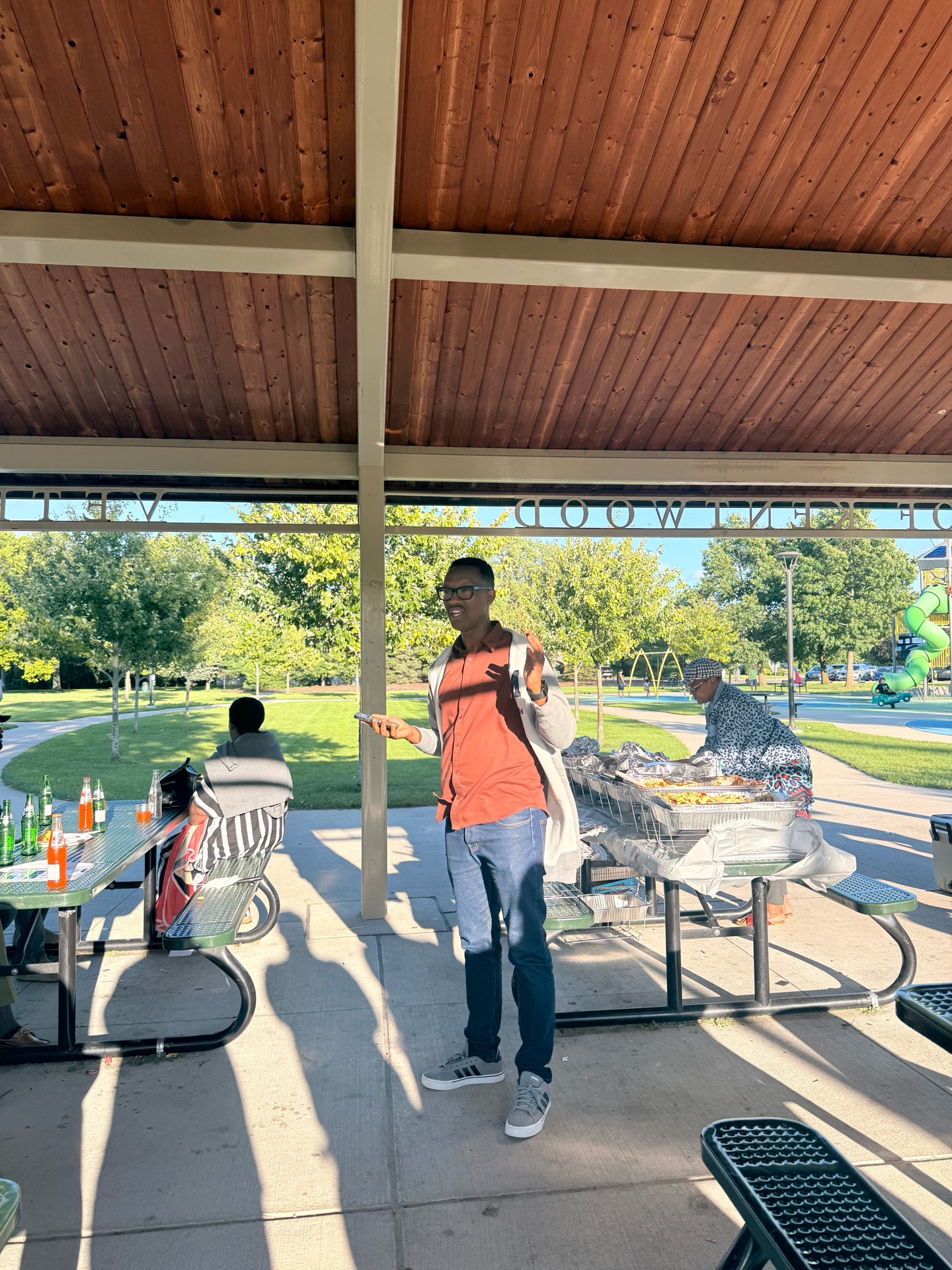 Families and community members gather under an outdoor pavilion for Iwacu Rwanda Family Day.